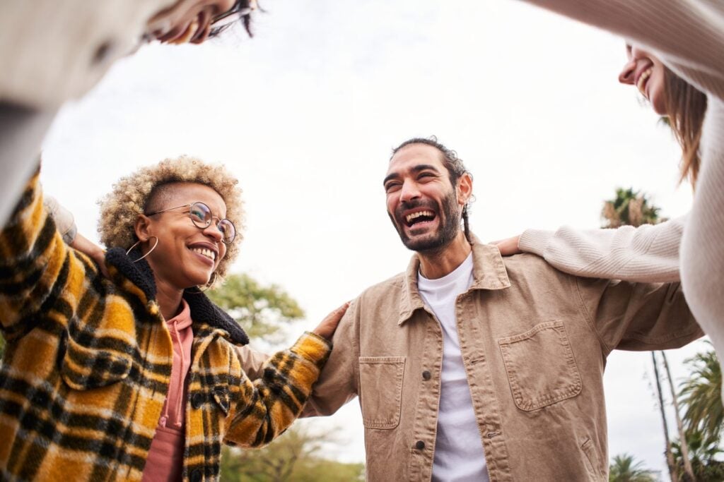 group of clients happily spending time outdoors, concept of group therapy
